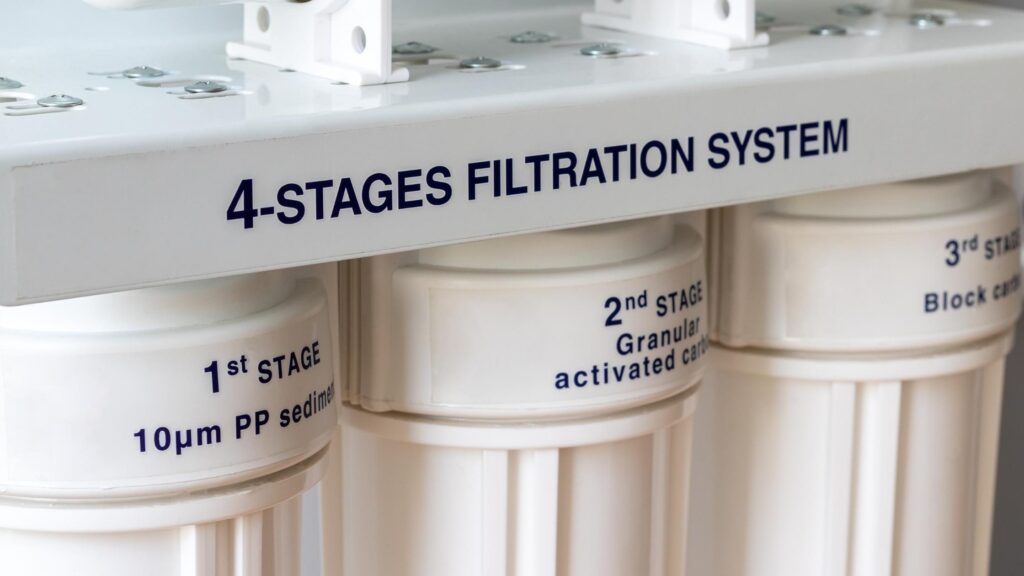 A modern reverse osmosis system installed under a kitchen sink, featuring multiple filtration stages for removing contaminants and providing clean, purified drinking water directly from the tap in a residential setting.