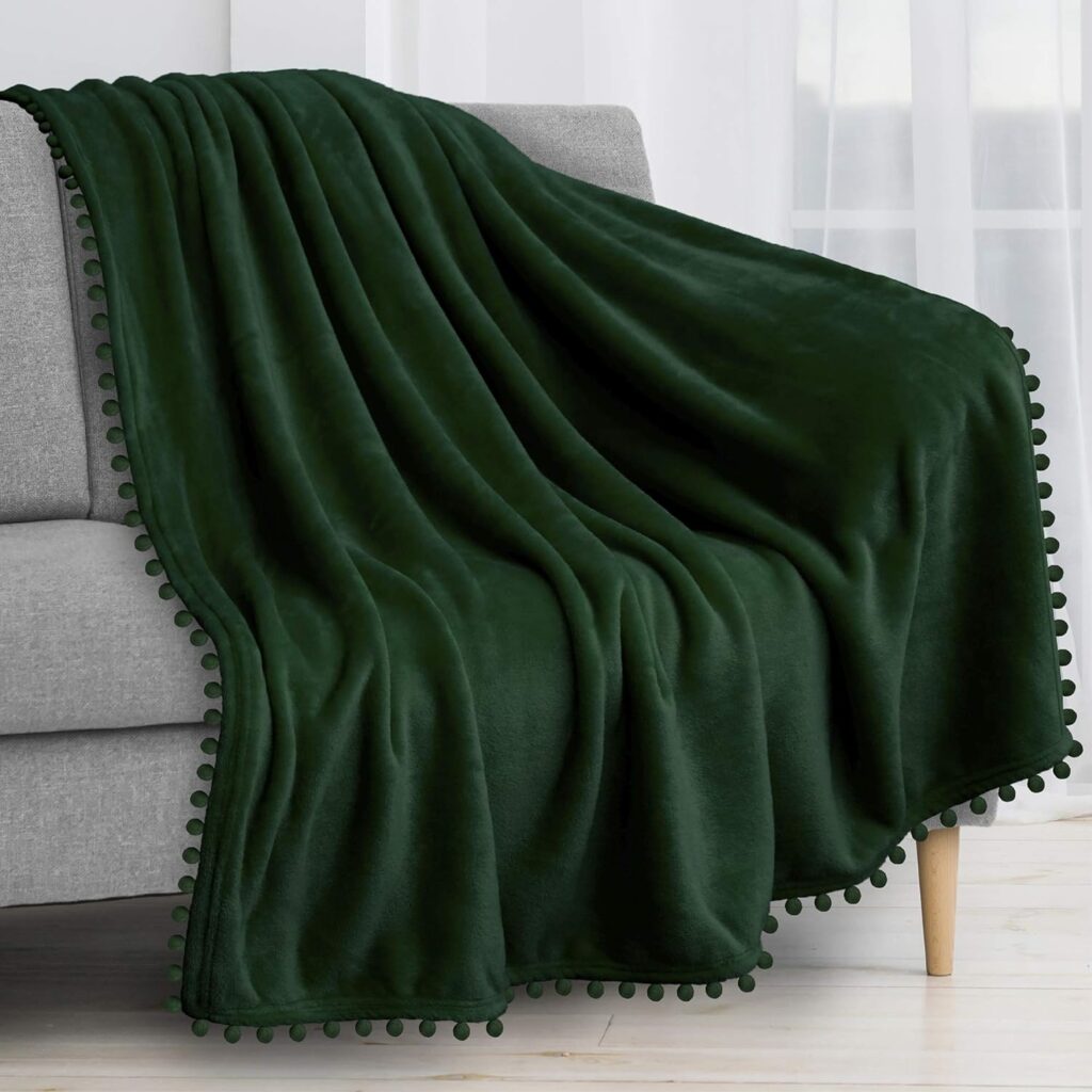 Cozy emerald green throw blanket draped over a sofa, adding a touch of luxury.